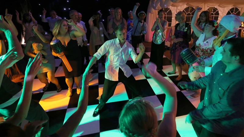 Guests dancing at a wedding reception with a DJ